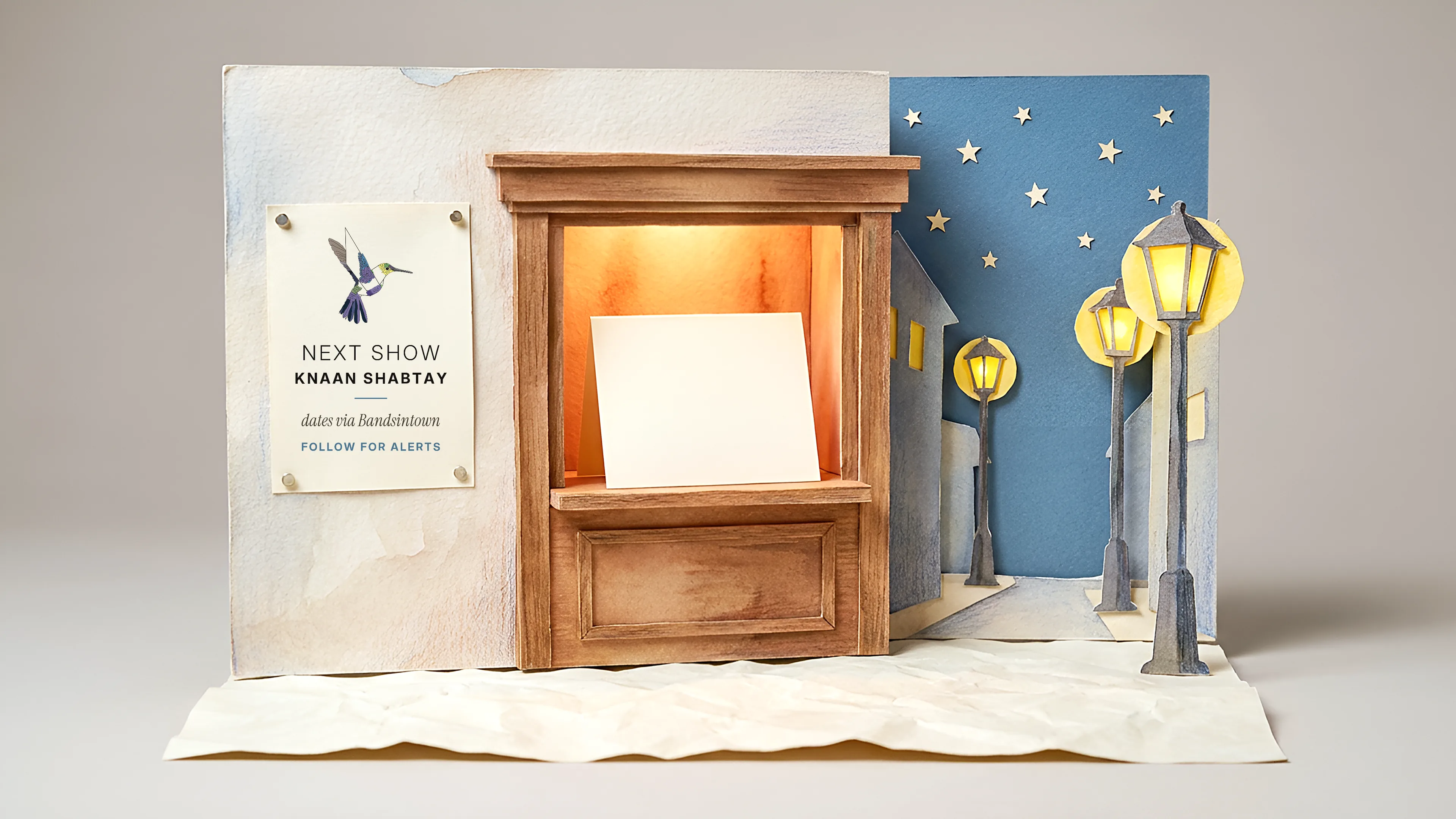 Paper box office with a lit window, and a night street with stars and lamps